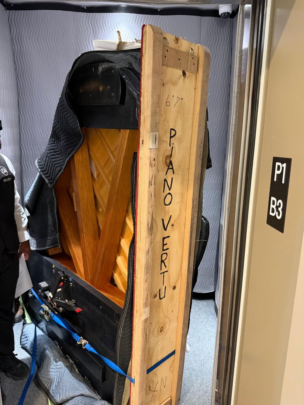 Piano à queue de 6 pi 7 po sur sa planche dans un ascenseur