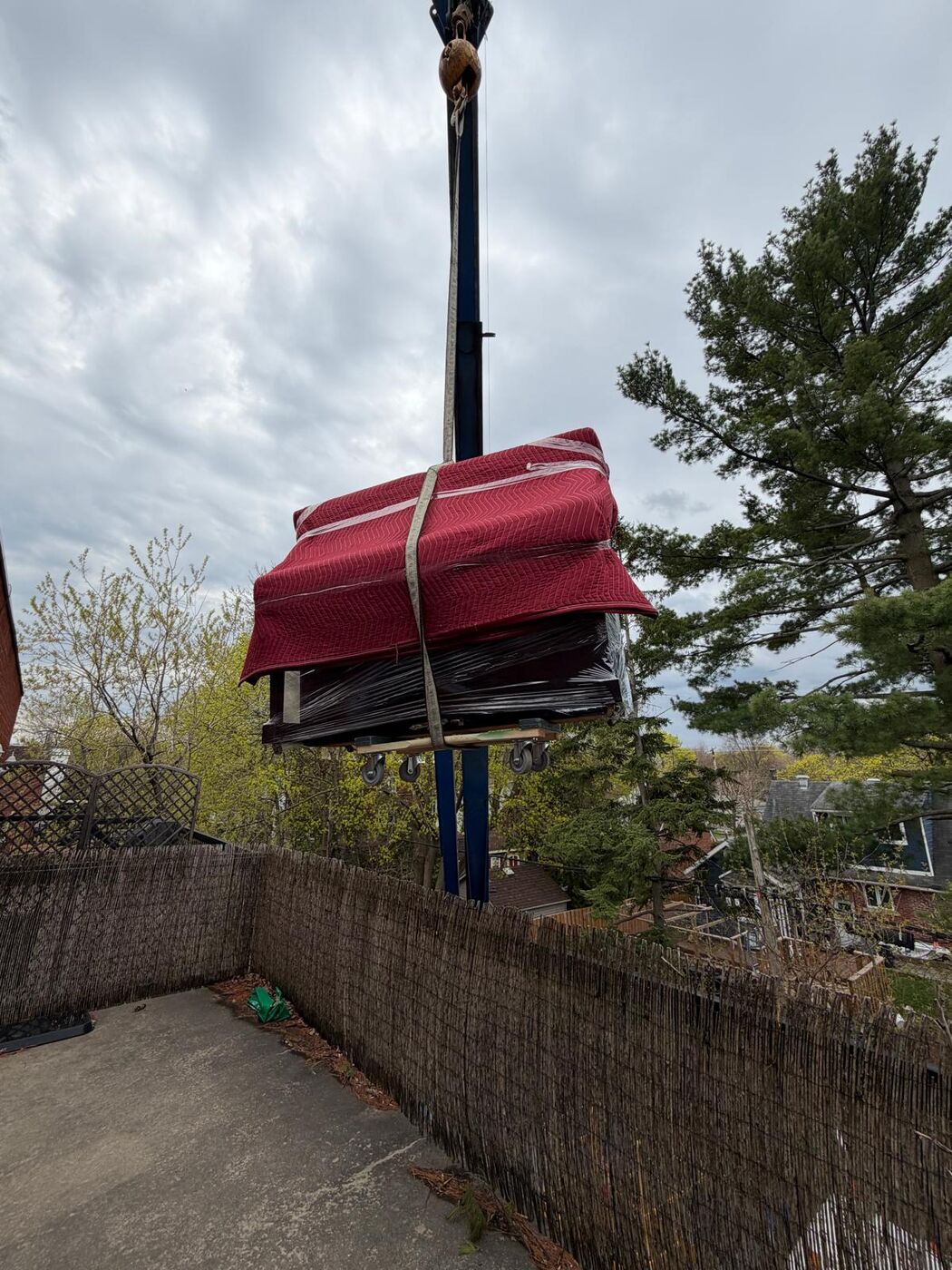 Piano à queue emballé soulevé par la grue jusqu'au balcon