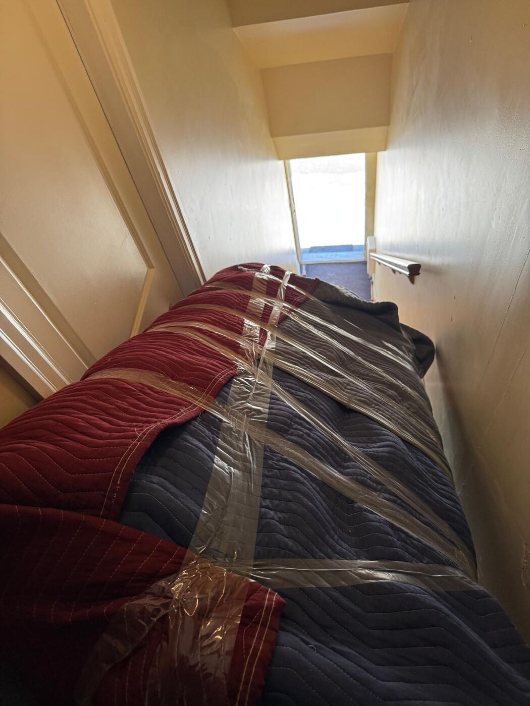 Sofa surdimensionné emballé descendu dans un escalier étroit